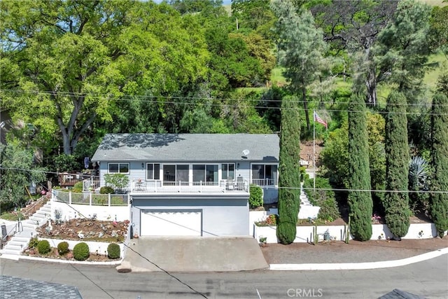 ranch-style house featuring an attached garage, driveway, and stairs