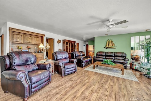 living room with light wood-style floors and a ceiling fan