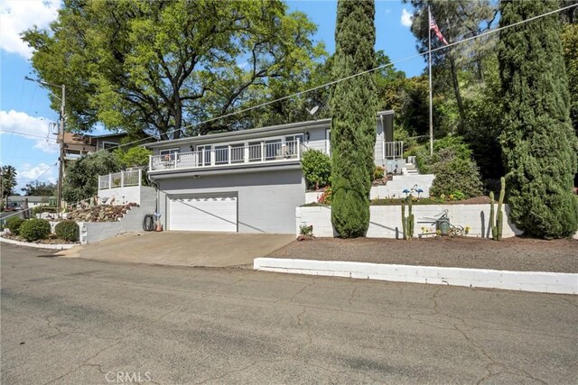 view of front of house with a garage, a balcony, and concrete driveway