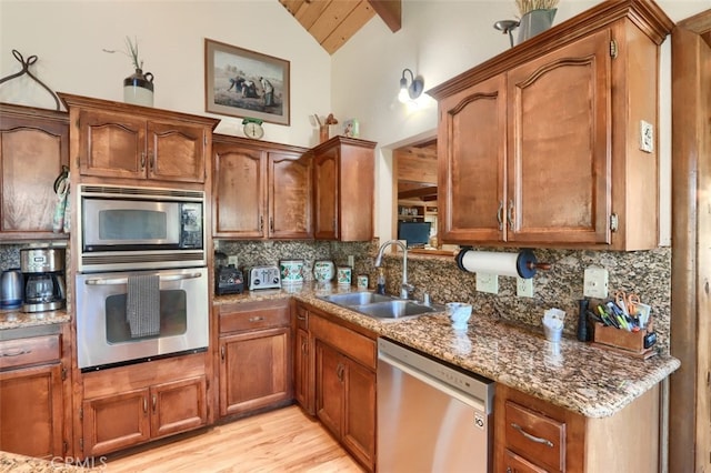 36575 Mudge Ranch Rd, Coarsegold, CA 93614 - kitchen featuring a sink, vaulted ceiling, stainless steel appliances, stone counters, and backsplash
