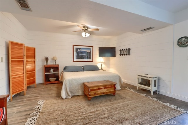 36575 Mudge Ranch Rd, Coarsegold, CA 93614 - bedroom with a wood stove, visible vents, ceiling fan, and wood finished floors