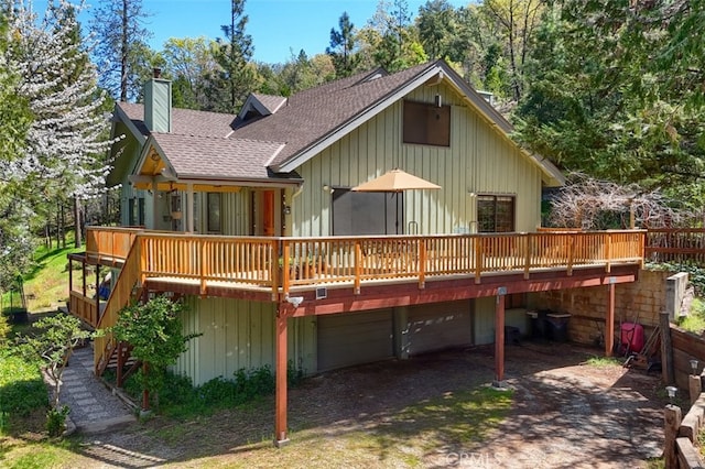 36575 Mudge Ranch Rd, Coarsegold, CA 93614 - back of property with an attached garage, a chimney, dirt driveway, a wooden deck, and roof with shingles
