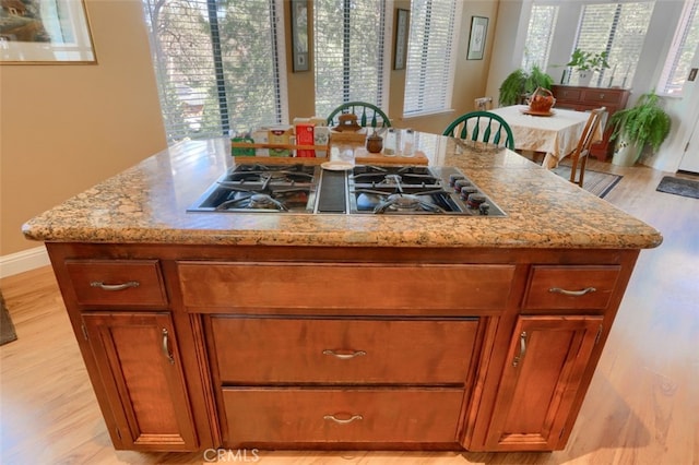 36575 Mudge Ranch Rd, Coarsegold, CA 93614 - kitchen with light wood finished floors, a center island, brown cabinets, and stovetop with downdraft