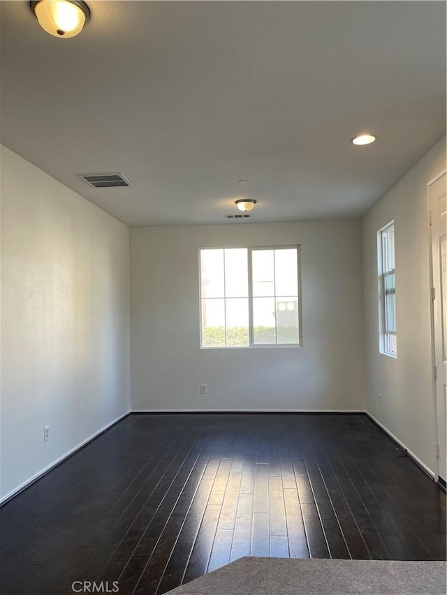 1800 E Lakeshore Dr Unit 302, Lake Elsinore, CA 92530 - spare room featuring a wealth of natural light, visible vents, baseboards, and dark wood finished floors