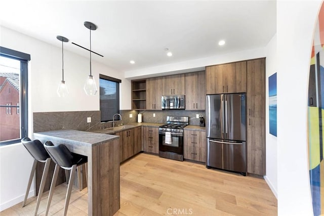 kitchen with a kitchen breakfast bar, open shelves, tasteful backsplash, a peninsula, and appliances with stainless steel finishes