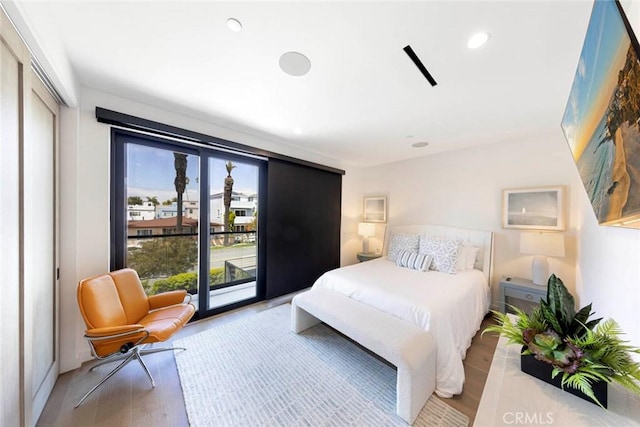 bedroom with recessed lighting, light wood-style flooring, and access to exterior