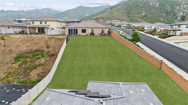 fenced backyard featuring a residential view and a mountain view