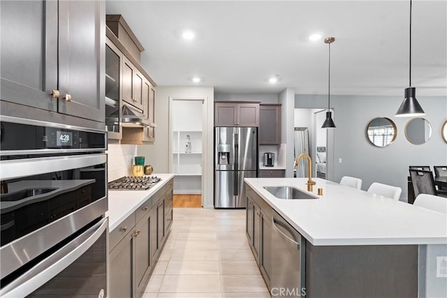 21123 Mill Valley Ct, Riverside, CA 92507 - kitchen featuring stainless steel appliances, light countertops, a kitchen island with sink, decorative light fixtures, and recessed lighting