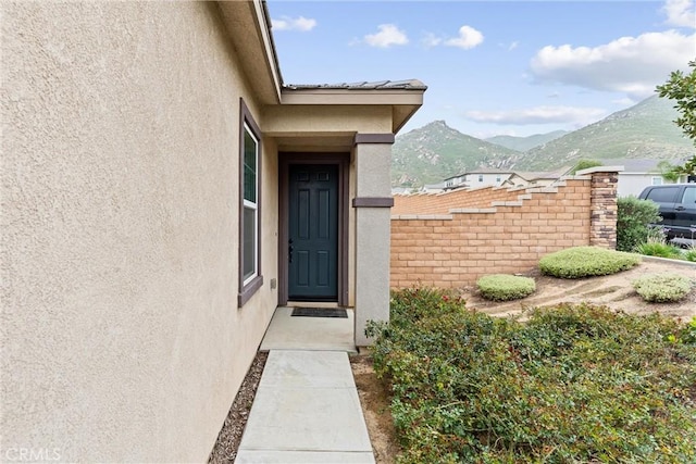 doorway to property featuring a mountain view and stucco siding