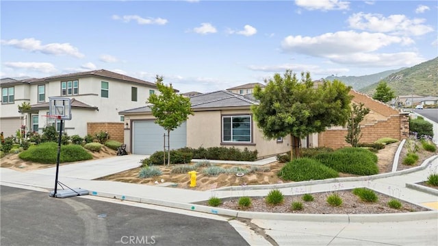 21123 Mill Valley Ct, Riverside, CA 92507 - view of front of home with driveway, a mountain view, stucco siding, and a garage