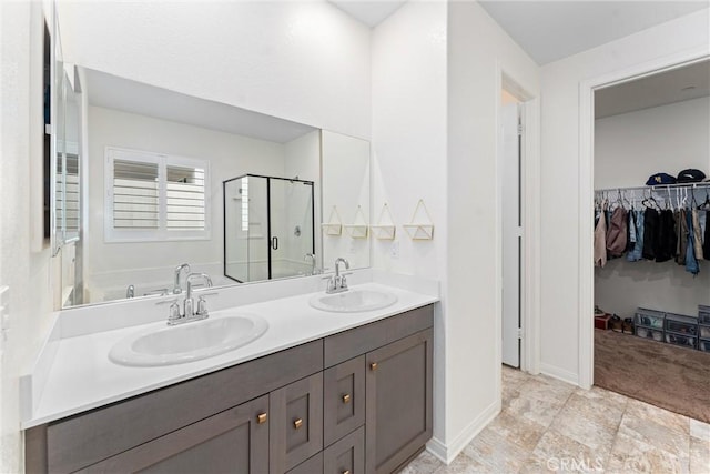 full bathroom featuring a stall shower, a walk in closet, and double vanity