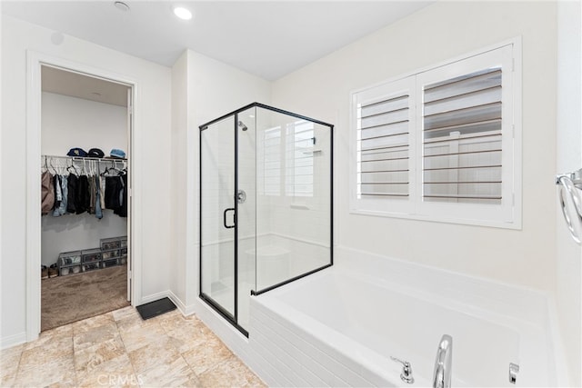 full bathroom featuring a shower stall, a walk in closet, and a bath