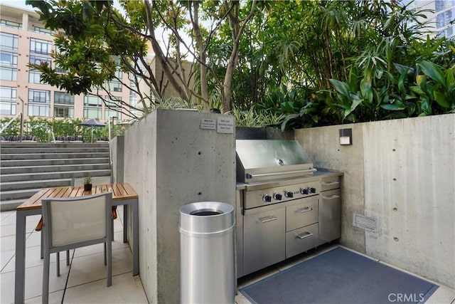 view of patio featuring area for grilling, visible vents, fence, and an outdoor kitchen