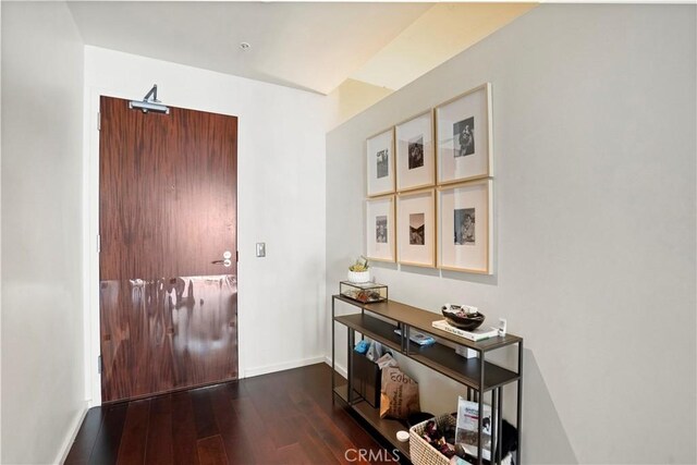 hall featuring baseboards and hardwood / wood-style flooring