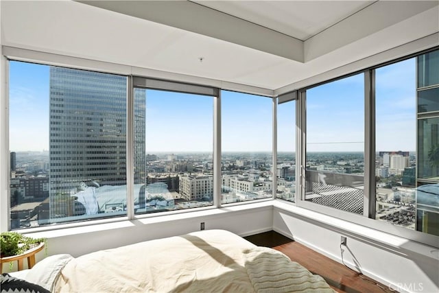 bedroom with a city view and wood finished floors