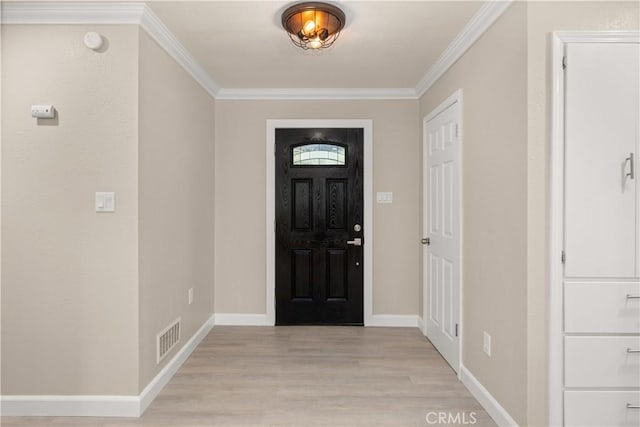 entrance foyer with crown molding, visible vents, baseboards, and light wood-style floors
