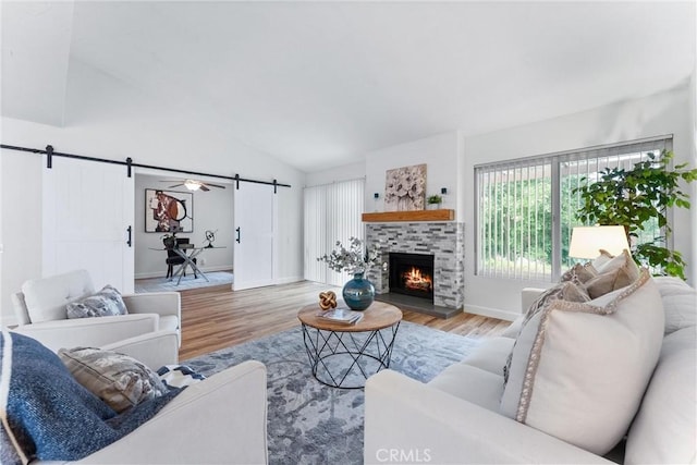 28133 Espinoza, Mission Viejo, CA 92692 - living room with a barn door, vaulted ceiling, wood finished floors, a fireplace, and baseboards