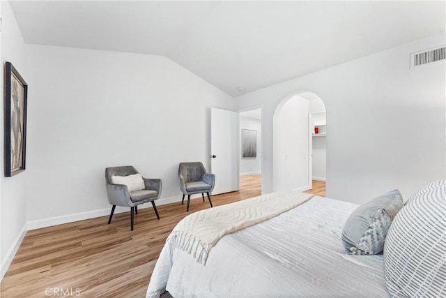 28133 Espinoza, Mission Viejo, CA 92692 - bedroom featuring lofted ceiling, light wood finished floors, visible vents, arched walkways, and baseboards