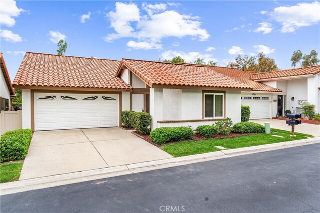 28133 Espinoza, Mission Viejo, CA 92692 - mediterranean / spanish-style house featuring a garage, driveway, stucco siding, and a tiled roof
