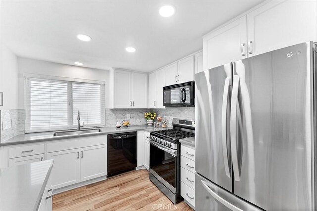 28133 Espinoza, Mission Viejo, CA 92692 - kitchen featuring light wood-style flooring, a sink, white cabinetry, backsplash, and black appliances