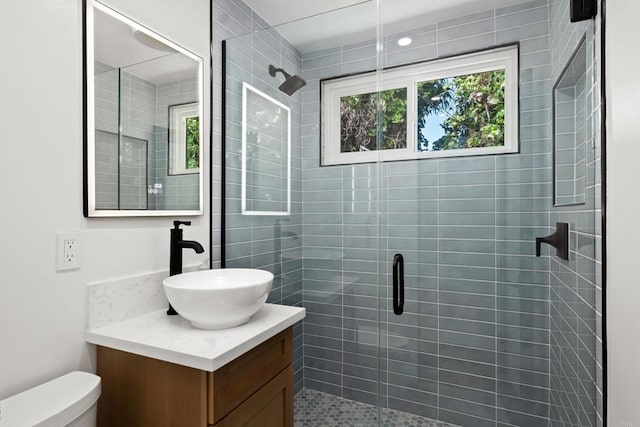 full bath featuring a stall shower, toilet, and vanity