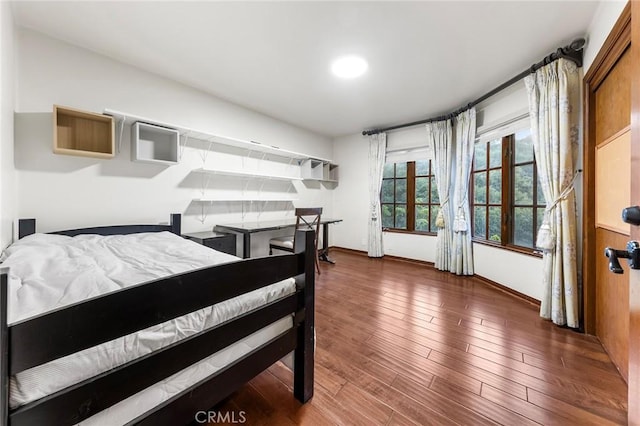 bedroom featuring baseboards and wood finished floors