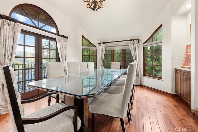 dining area featuring a healthy amount of sunlight, baseboards, light wood-style floors, and french doors