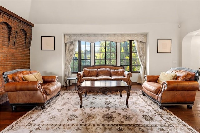 living room with arched walkways and hardwood / wood-style floors