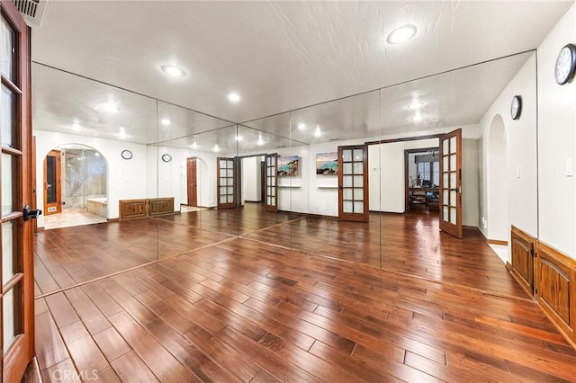 workout room with french doors, arched walkways, wood-type flooring, and recessed lighting