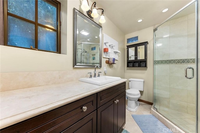bathroom with a shower stall, vanity, tile patterned floors, baseboards, and toilet