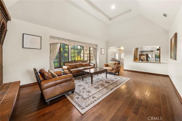 living area with arched walkways, baseboards, dark wood-type flooring, and visible vents