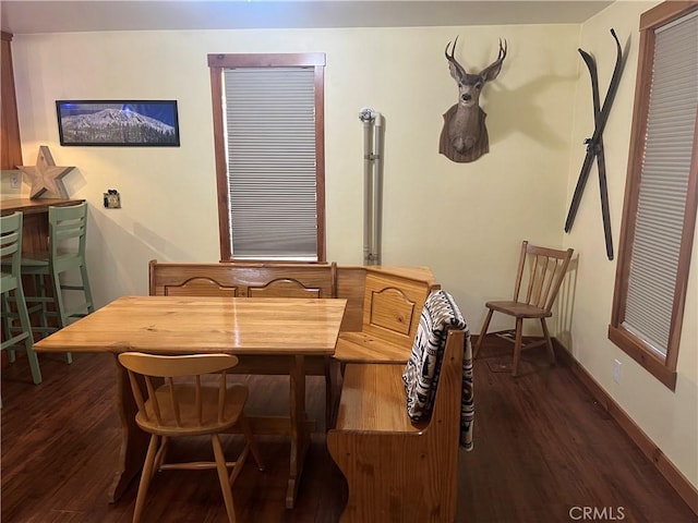 dining room with dark wood-type flooring and baseboards
