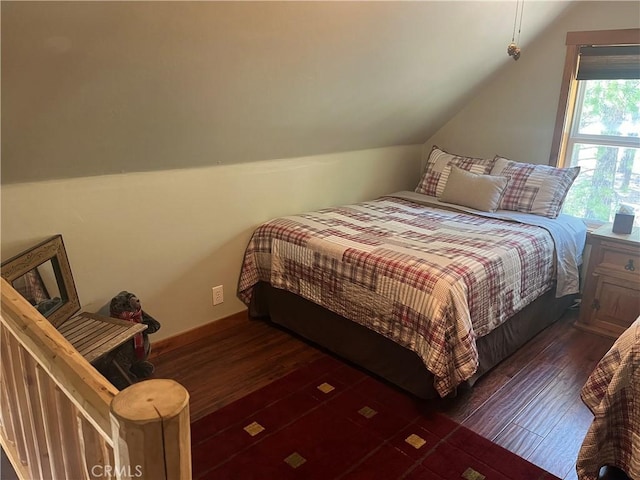 bedroom featuring dark wood finished floors and lofted ceiling