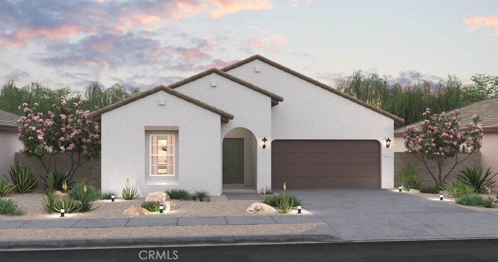 mediterranean / spanish-style house with a garage, driveway, stucco siding, and a tile roof