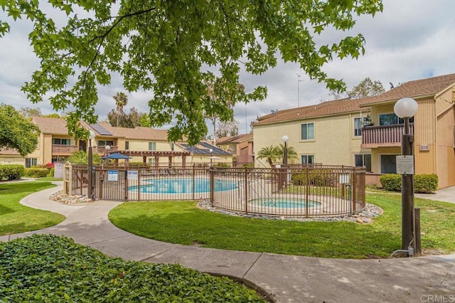 community pool with a lawn and fence