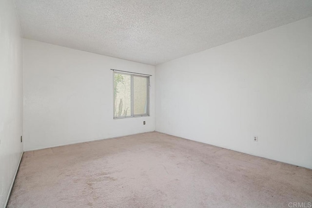 carpeted empty room featuring a textured ceiling