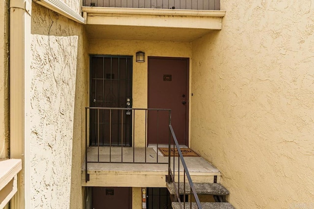 doorway to property featuring stucco siding