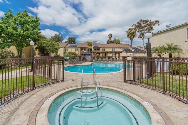 community pool featuring a patio, a community hot tub, and fence