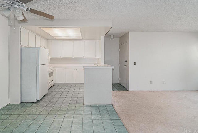 kitchen featuring freestanding refrigerator, a ceiling fan, white cabinets, and light countertops