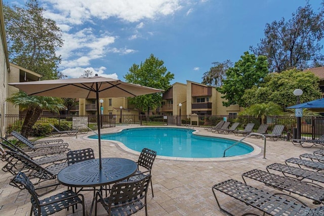 pool with a patio and fence