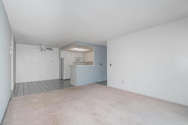 unfurnished living room featuring a textured ceiling, carpet, and ceiling fan