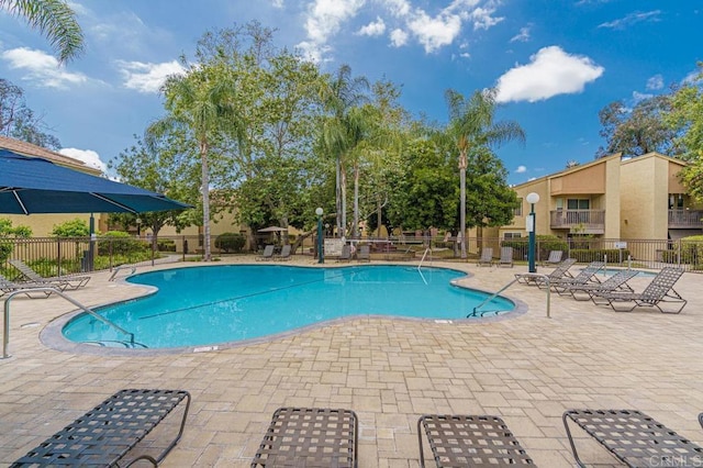 pool featuring fence and a patio area