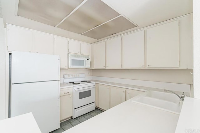 kitchen featuring white appliances, light tile patterned floors, a sink, and light countertops