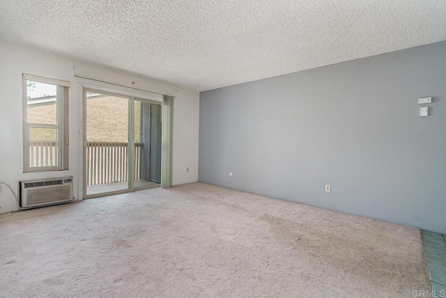 carpeted empty room with a textured ceiling and a wall mounted air conditioner