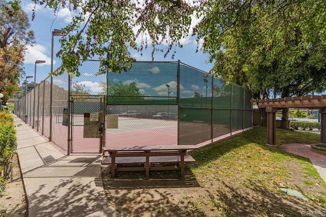 view of sport court with a gate and fence