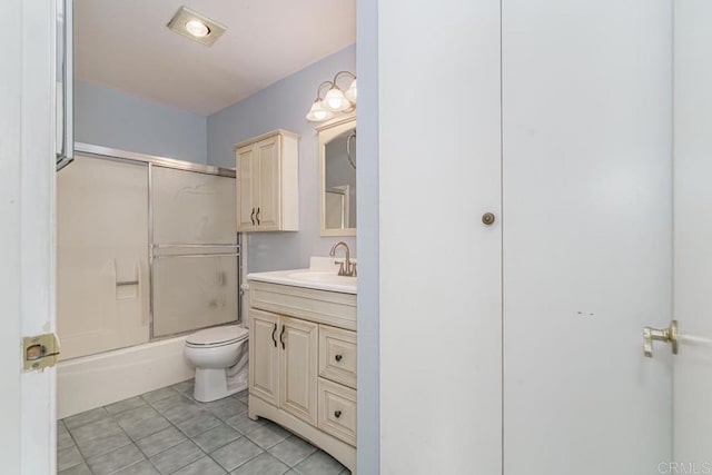 full bathroom with vanity, tile patterned floors, combined bath / shower with glass door, and toilet