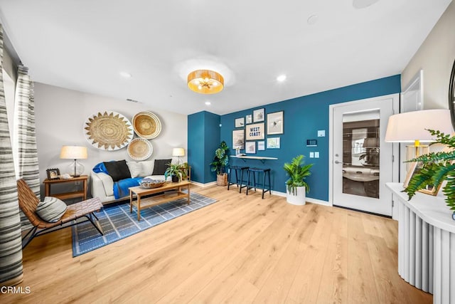living area featuring wood finished floors, baseboards, visible vents, and recessed lighting