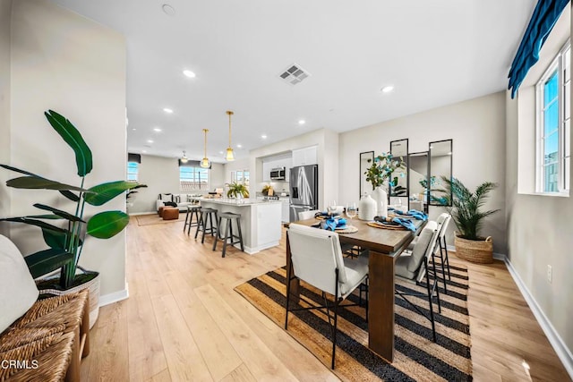 dining room with light wood-type flooring, baseboards, visible vents, and recessed lighting