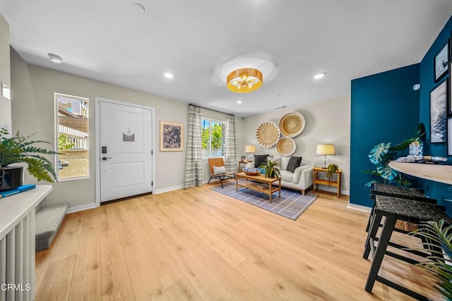 living area featuring light wood-style flooring, baseboards, and recessed lighting