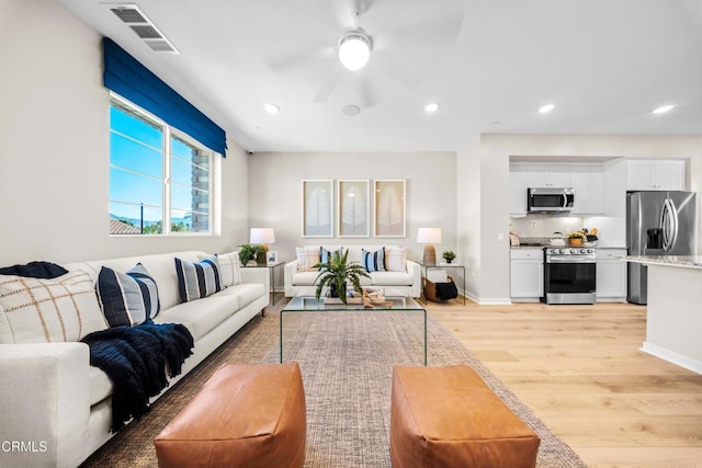 living area featuring recessed lighting, visible vents, light wood-type flooring, and a ceiling fan